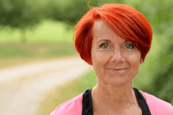 A woman with red hair smiling at the camera.